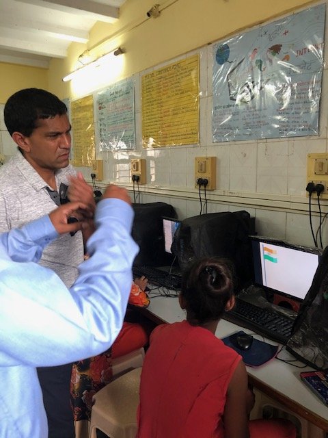 Visitors watching girls working at computers in the Door Step School computer centre