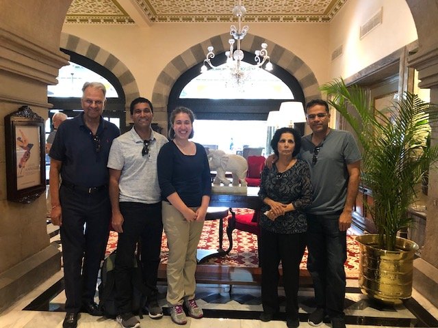 Five members of the visiting group standing together in a hotel lobby in Mumbai