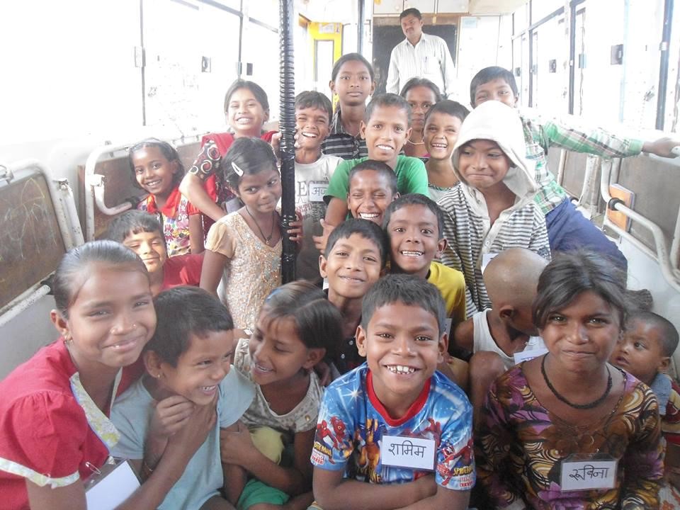 Children smiling inside the School on Wheels bus classroom
