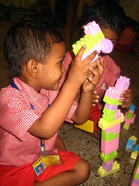 A young boy examining a toy built from building blocks at a play centre